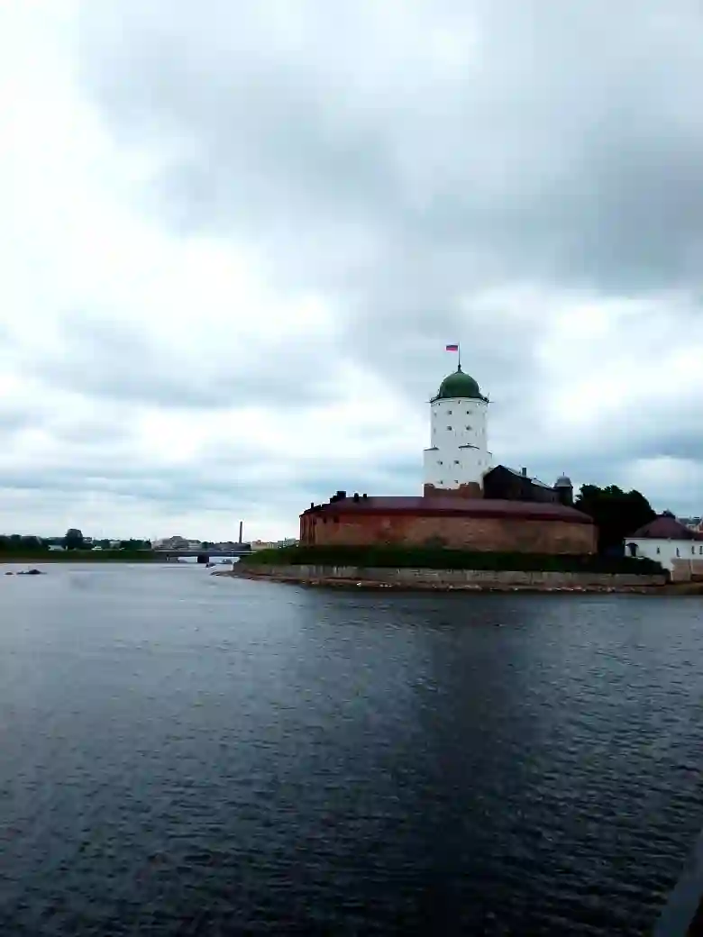 Крепость с белыми стенами и зелёной крышей, окружённая водой