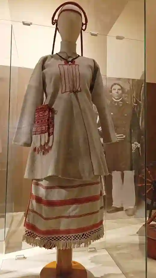 Традиционный народный костюм: длинная рубаха с вышивкой и юбка в полоску с бахромой на манекене